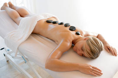 Bei der Hot-Stone-Massage werden warme und kalte Steine auf die Energiezentren des Körpers gelegt, der dazu sanft massiert wird