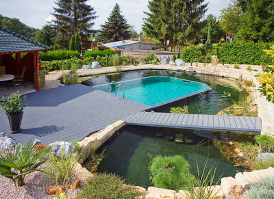 Die Kombination aus Swimmingpool und Gartenteich passt sich perfekt in naturnah angelegte Gärten ein