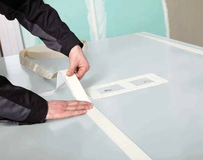 Die Verklebung der Platten erfolgt entweder durch das Montage-Kit oder durch den Flächenkleber. Nachdem das Klebeband und die Silikonraupen aufgetragen wurden, kann die Platte einfach an die Wand geklebt werden.