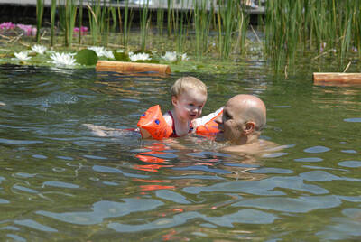 Groß und Klein genießen das Bad im Schwimmteich